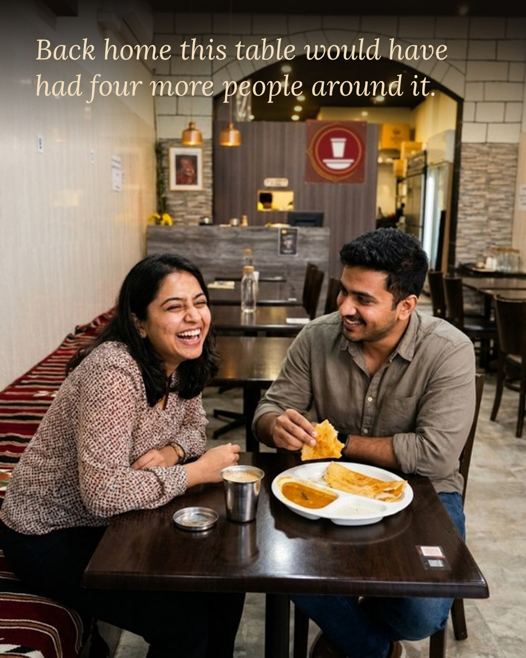 Two people eating dosa at a table